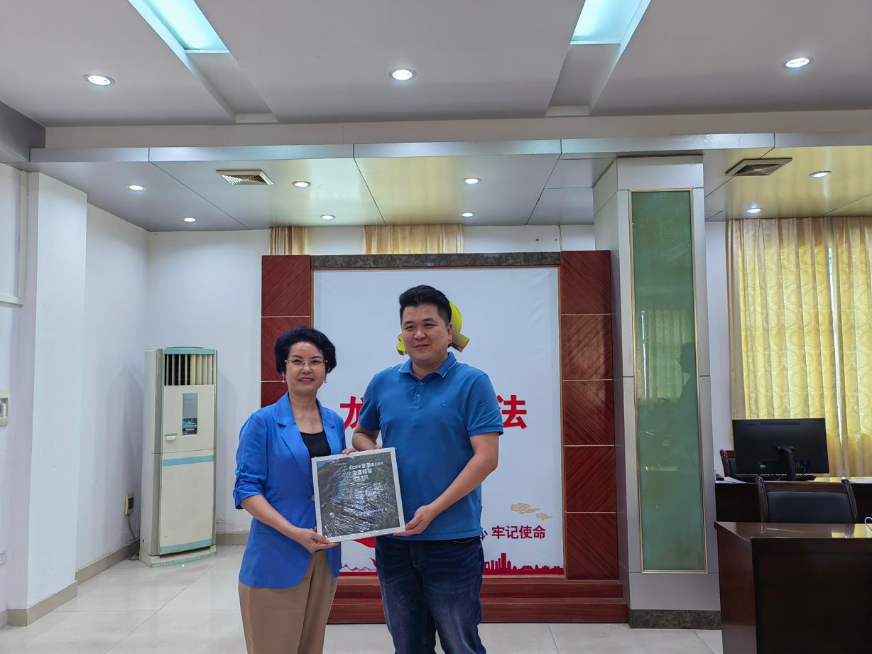 1652921806611123 何总代表协会赠予书给龙江镇党委副书记邹建新(1).jpg